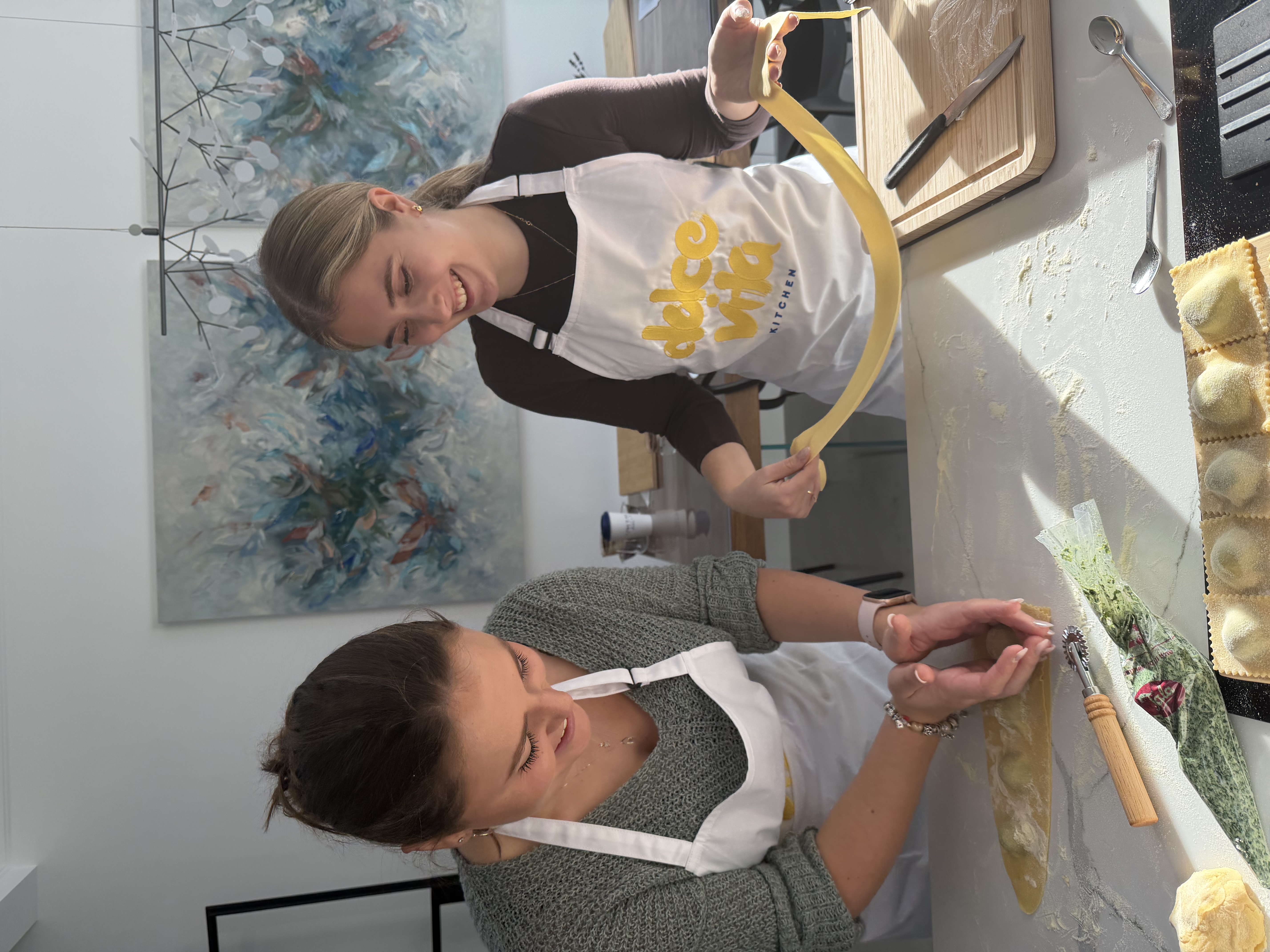 Two guests making pasta together, laughing